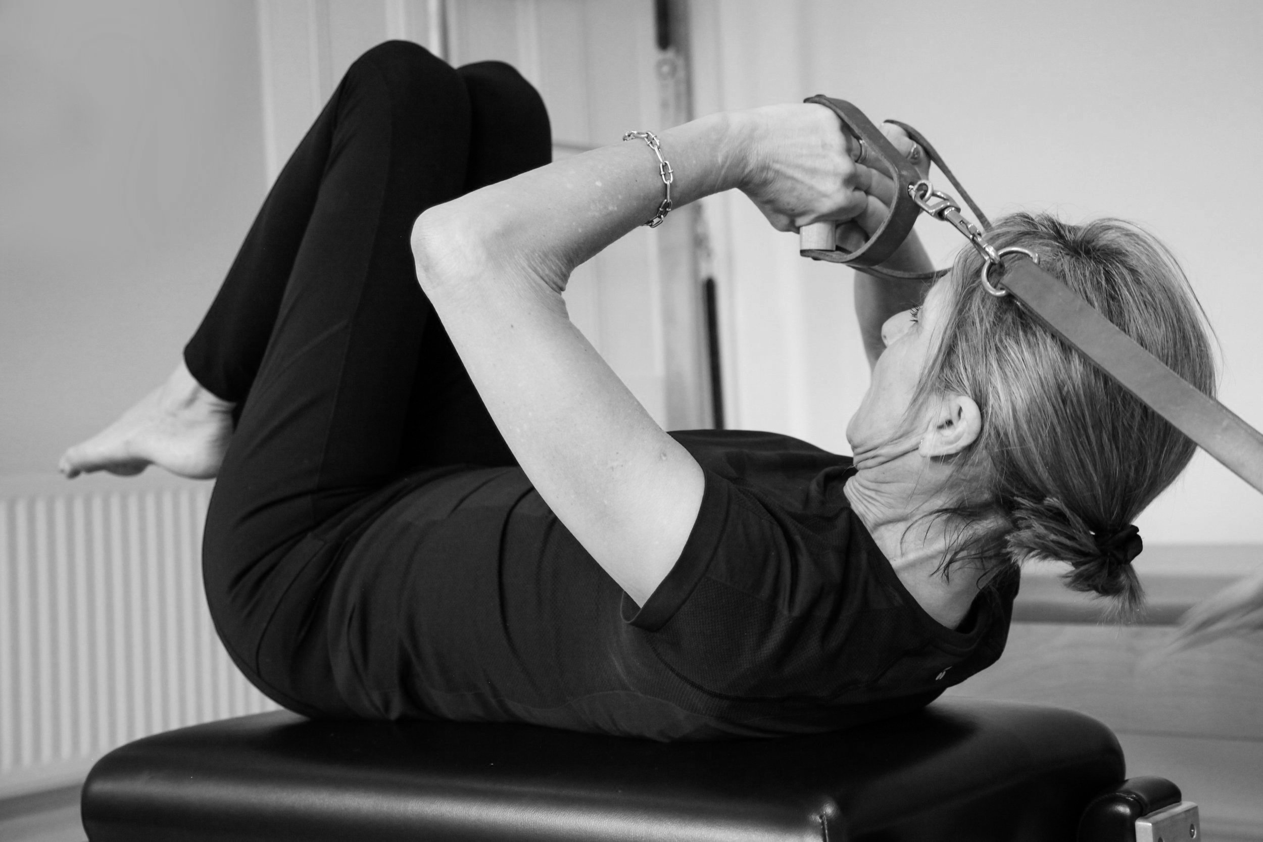 image of woman using a pilates reformer